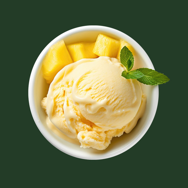 Mango ice cream in bowl with cut mango