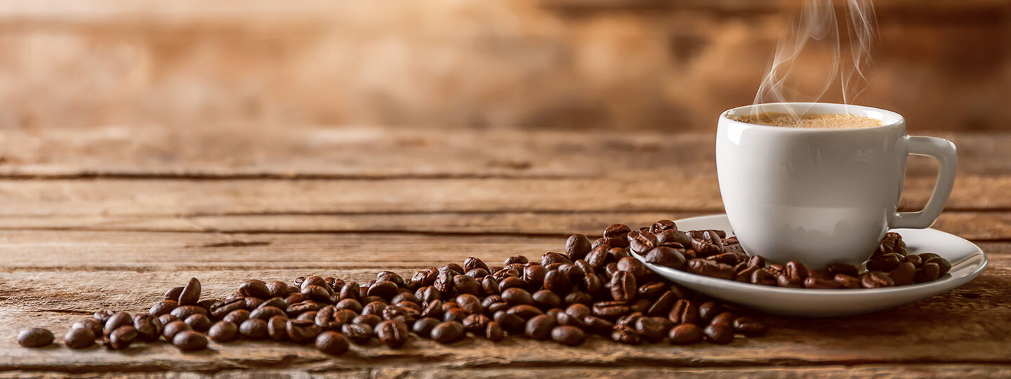 coffee in a cup with beans on the side