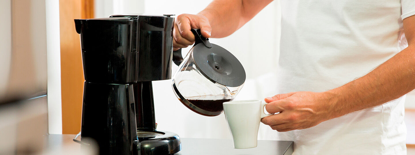 man pouring coffee into cup