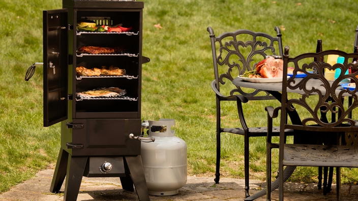 Cuisinart smoker, black, with food inside on patio