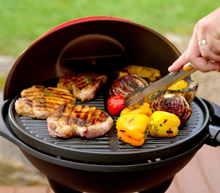 Electric grill cooking chicken breast, cabbage, peppers, and squash