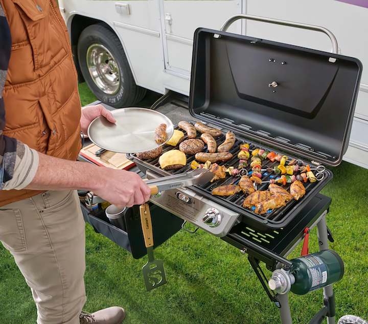 Food cooking on grill, sausages and chicken