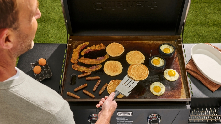 man cooking breakfast on griddle