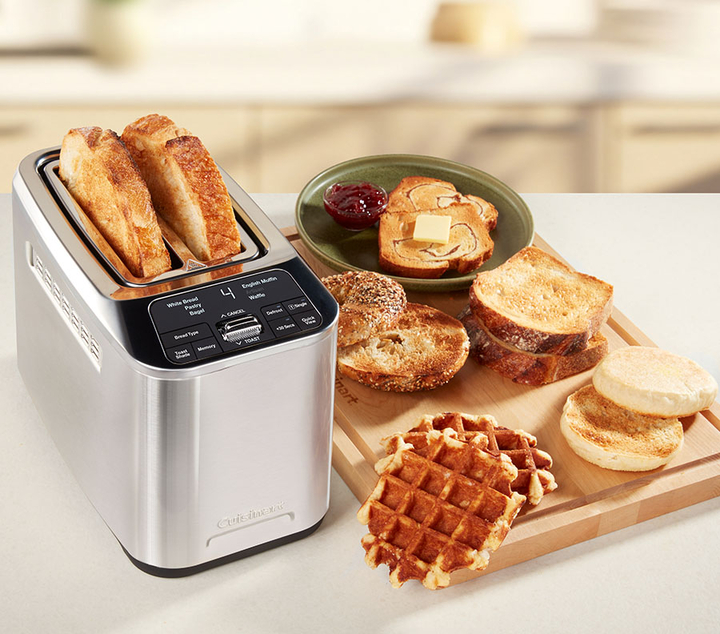 2 Slice Toaster with bread in it and a toast with jam next to it
