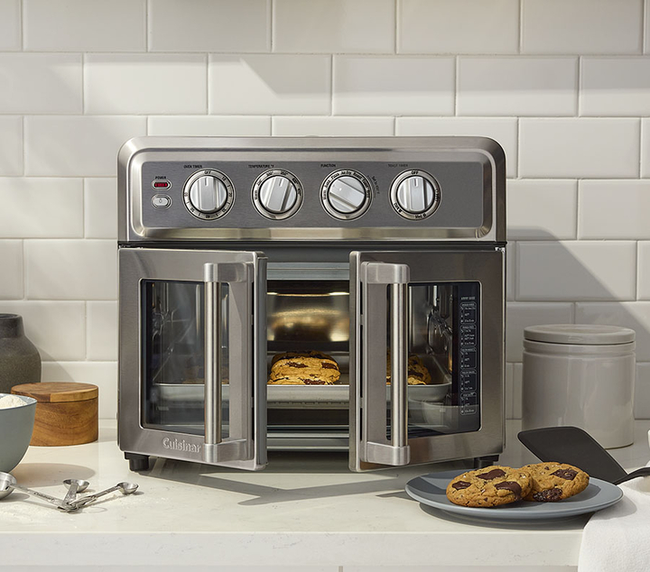 Artisan French Door Air Fryer Toaster Oven with doors open and backed cookies on a plate