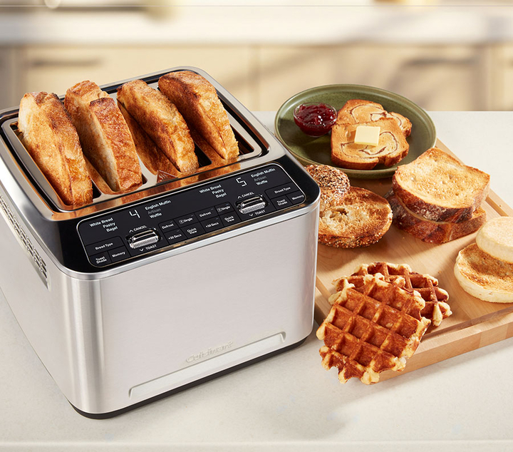 4 Slice Toaster with bread in it and a toast with jam next to it