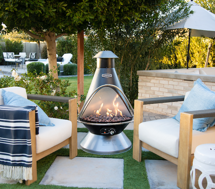 chimenea fire pit outside on patio with chairs around it