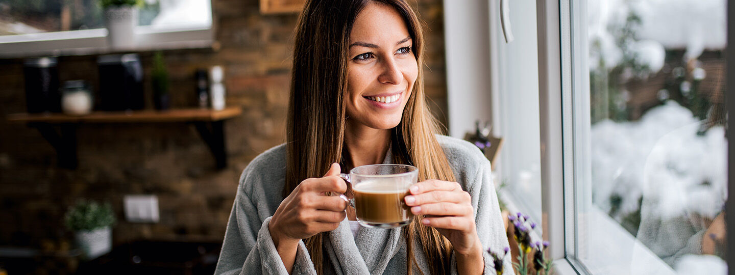 woman smiling and drinking coffee