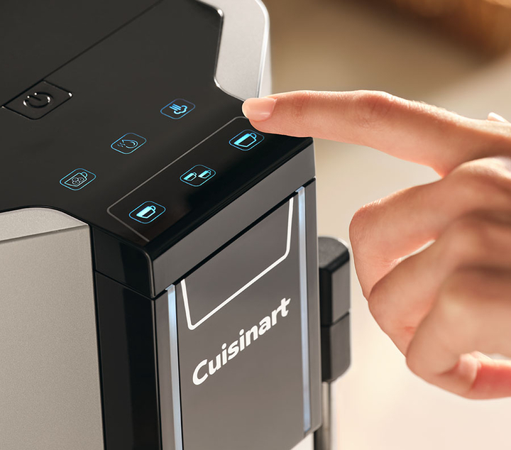 Finger pressing coffee cup icon on espresso machine